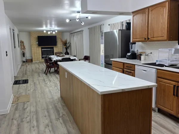 a kitchen with stainless steel appliances granite countertop a kitchen island a stove a refrigerator a sink and a microwave