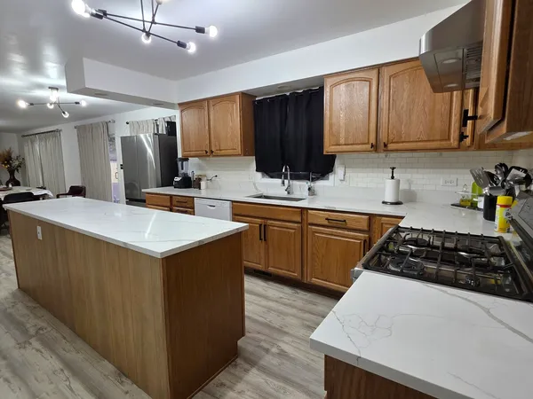 a kitchen with stainless steel appliances a sink stove and cabinets