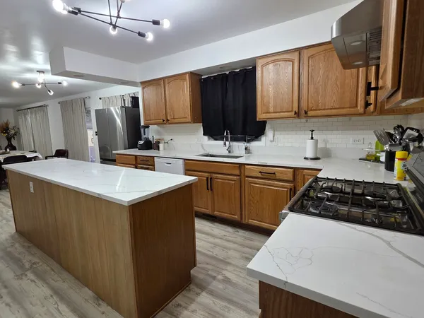 a kitchen with stainless steel appliances a sink stove and cabinets