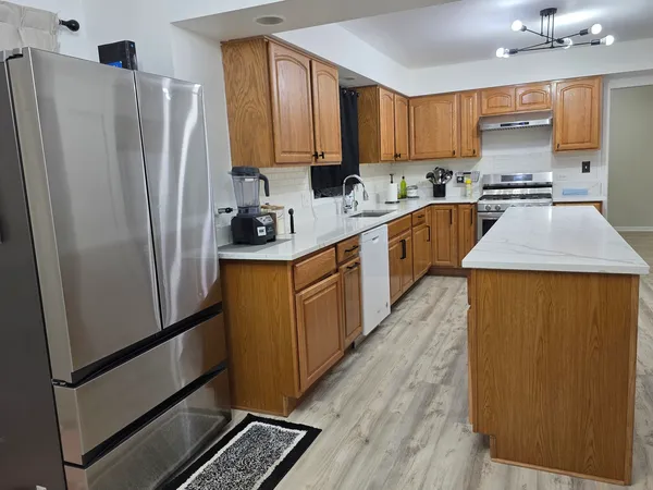 a kitchen with stainless steel appliances a refrigerator sink and cabinets