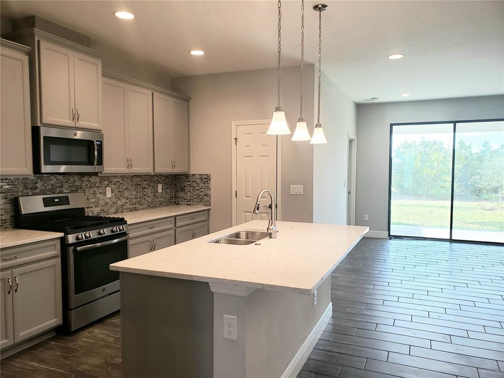 6206 Colmar Place Apollo Beach, FL 33572 - Photo 11 of 26 a kitchen with kitchen island a sink stainless steel appliances and cabinets