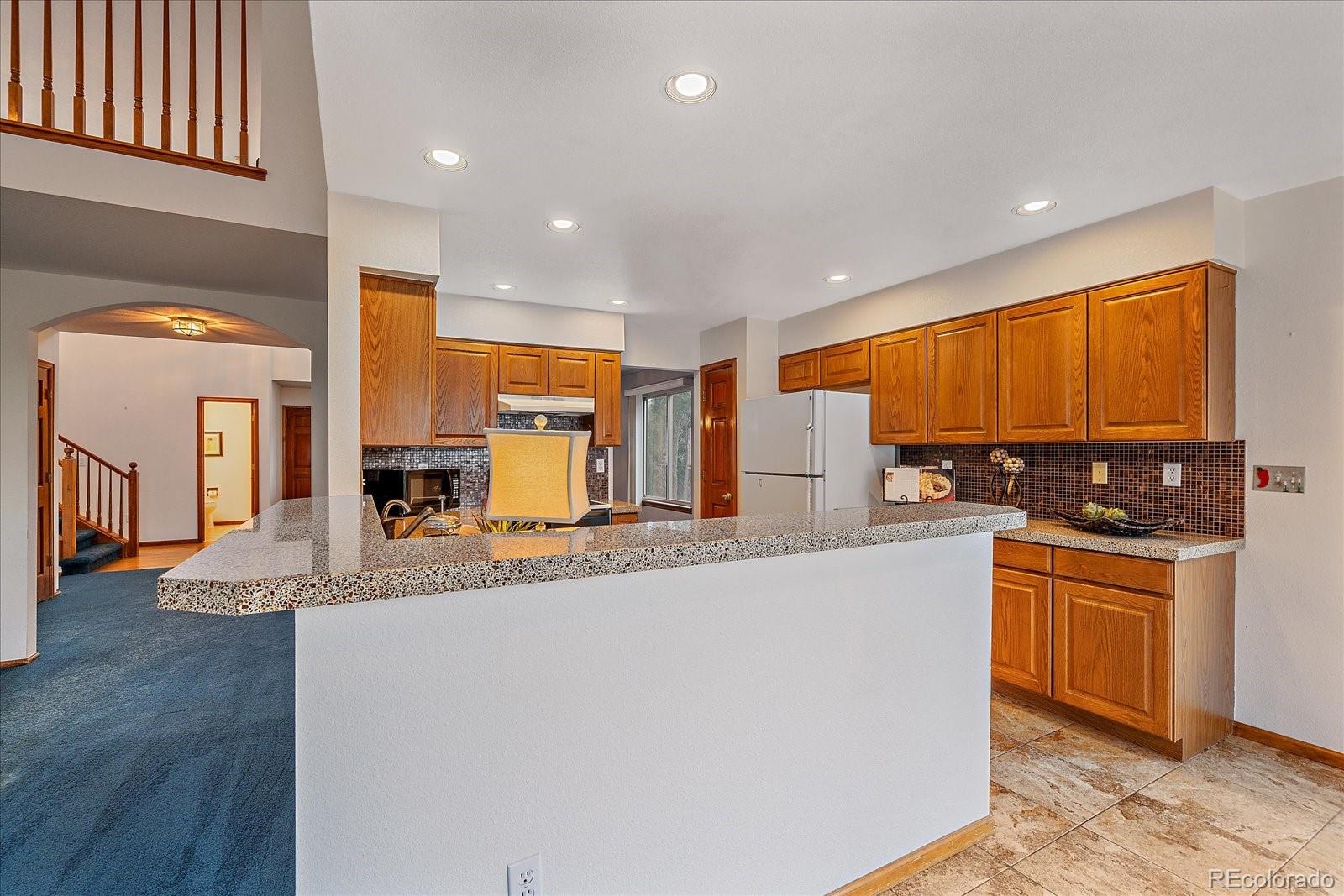 9875 Spring Hill Street Highlands Ranch, CO 80129 - Photo 14 of 38 a large kitchen with stainless steel appliances granite countertop a large window a oven and a sink