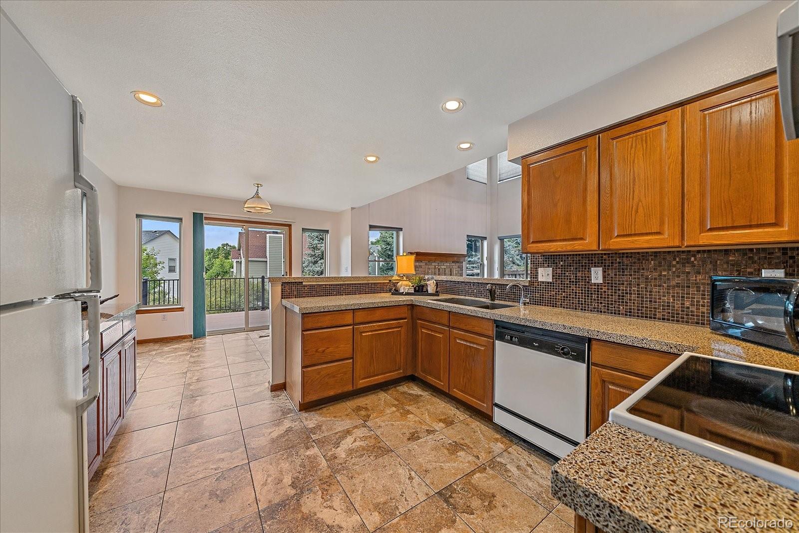 9875 Spring Hill Street Highlands Ranch, CO 80129 - Photo 16 of 38 a large kitchen with stainless steel appliances granite countertop a stove a sink and dishwasher