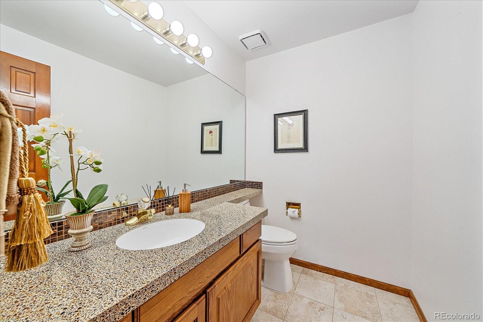 9875 Spring Hill Street Highlands Ranch, CO 80129 - Photo 21 of 38 a bathroom with a sink vanity granite and a mirror