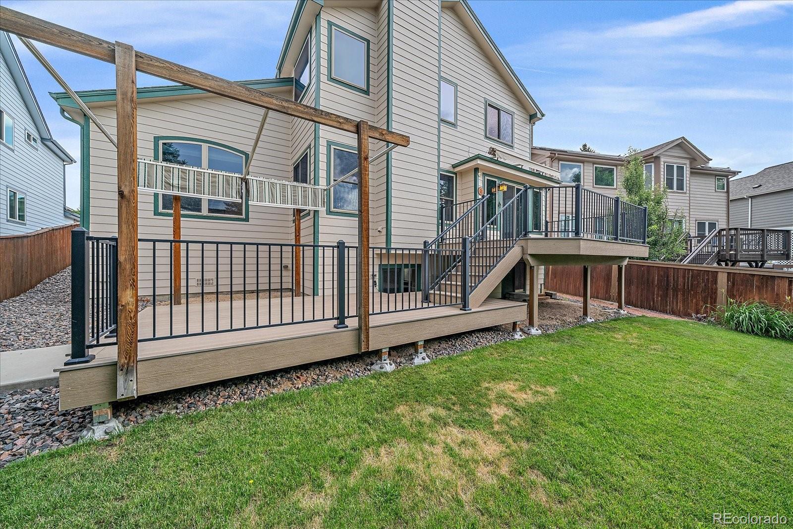 9875 Spring Hill Street Highlands Ranch, CO 80129 - Photo 34 of 38 a view of a house with a yard and a wooden fence