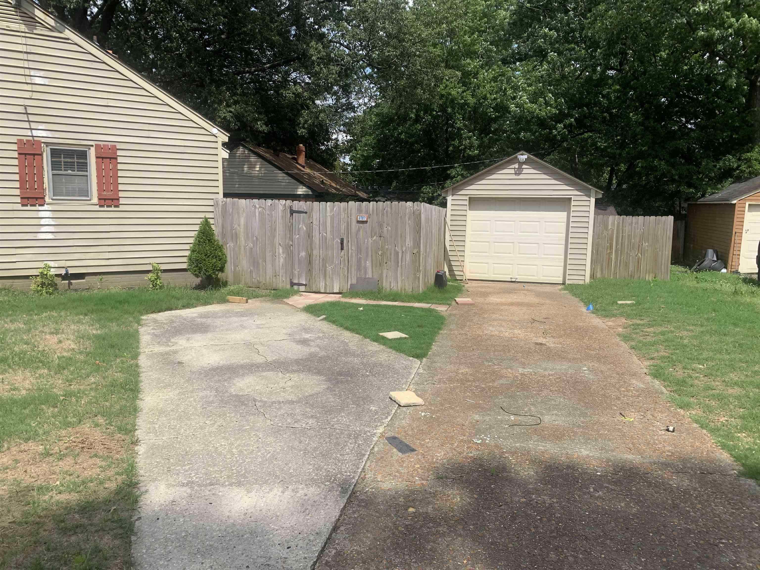3787 Rhodes Avenue Memphis, TN 38111 - Photo 2 of 23 View of concrete driveway, and a detached garage. Siding has been repaired and painted