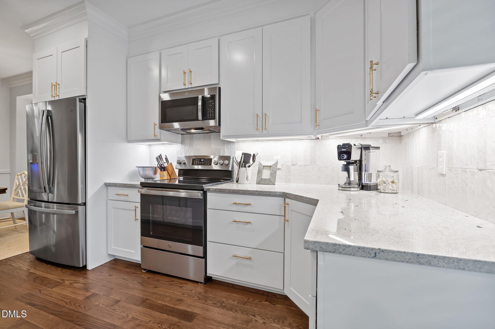 562 Weathergreen Drive Raleigh, NC 27615 - Photo 6 of 47 a kitchen with granite countertop a refrigerator stove and microwave with wooden floor
