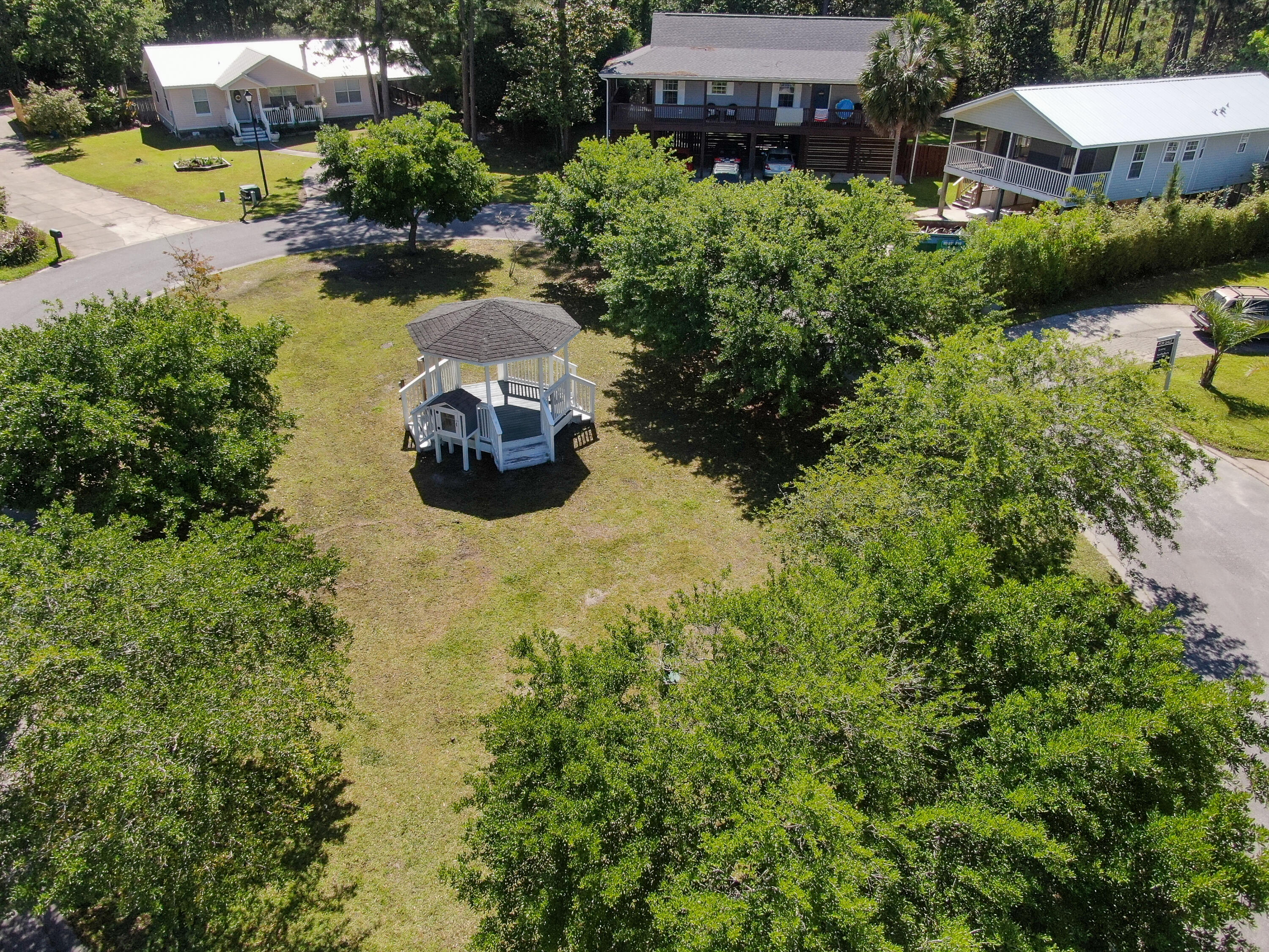 190 Plantation Way Santa Rosa Beach, FL 32459 - Photo 11 of 41 a view of a lake with lawn chairs and large trees