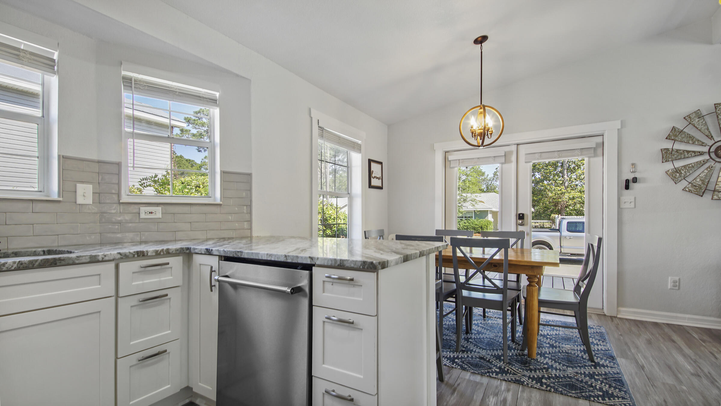 190 Plantation Way Santa Rosa Beach, FL 32459 - Photo 22 of 41 a kitchen with stainless steel appliances granite countertop sink stove and white cabinets with wooden floor