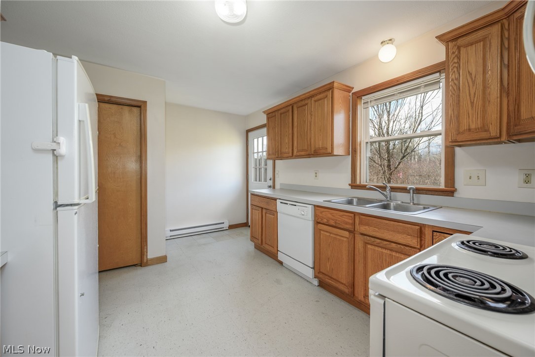 8464-8446 Tallmadge Road Diamond, OH 44412 - Photo 9 of 39 Kitchen with light flooring, white appliances, light countertops, wood finish cabinetry, and a baseboard heating unit