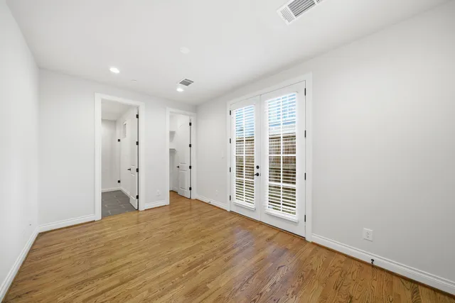 a view of a big room with wooden floor and windows