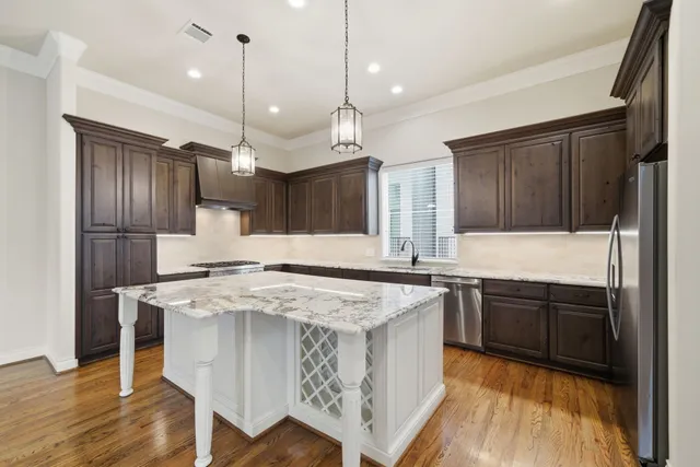 a kitchen with stainless steel appliances granite countertop a sink a stove and a refrigerator