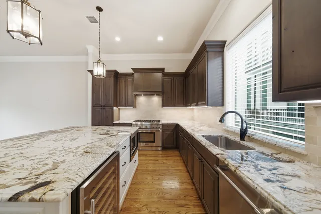 a kitchen with stainless steel appliances granite countertop sink stove and refrigerator
