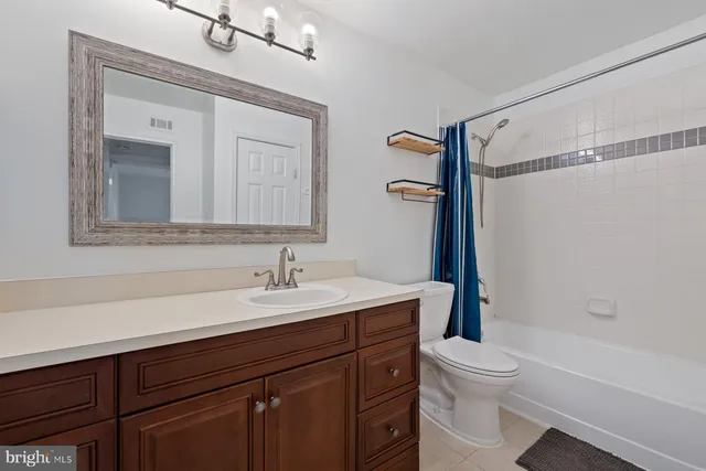 a bathroom with a sink a toilet a mirror and shower