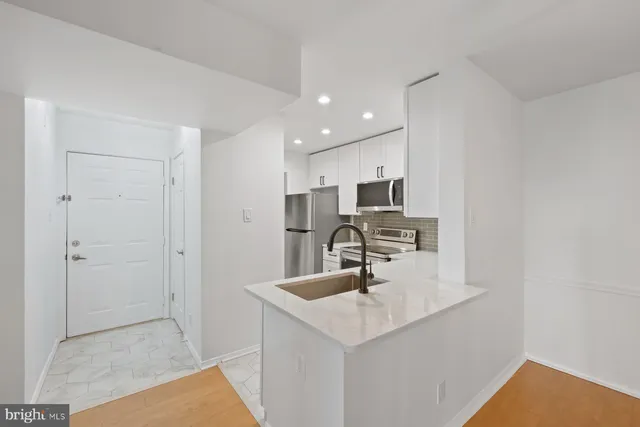 a kitchen with kitchen island a sink stainless steel appliances and cabinets