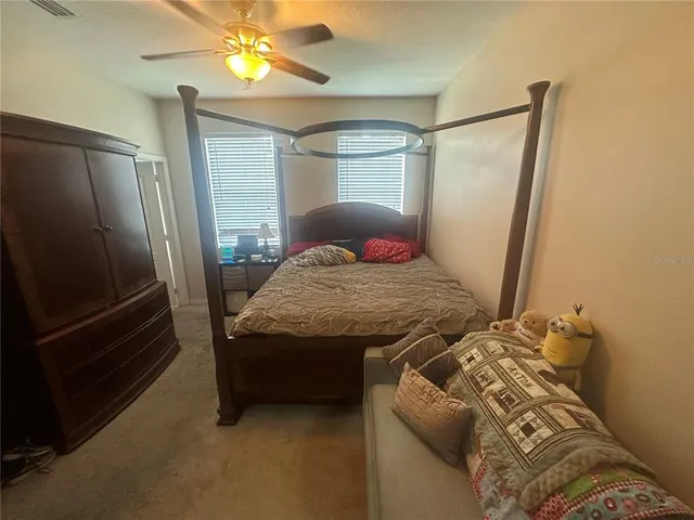 a bedroom with a bed and a refrigerator