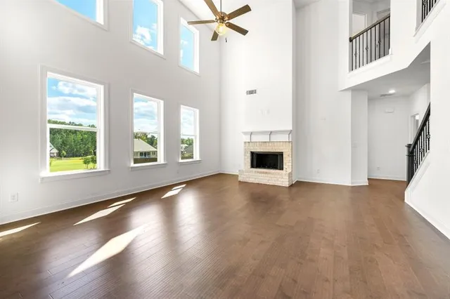 an empty room with windows and fireplace