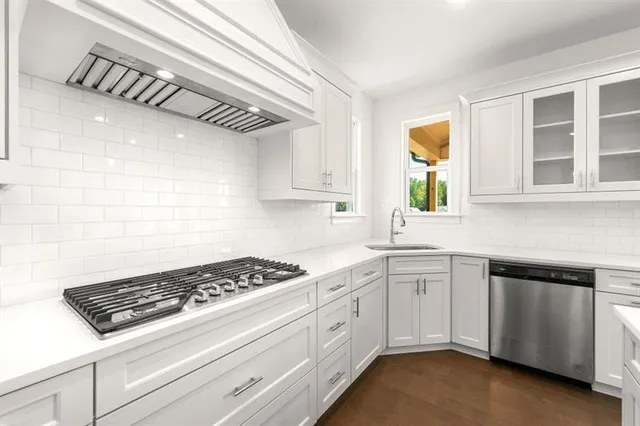 a kitchen with a stove a sink and cabinets