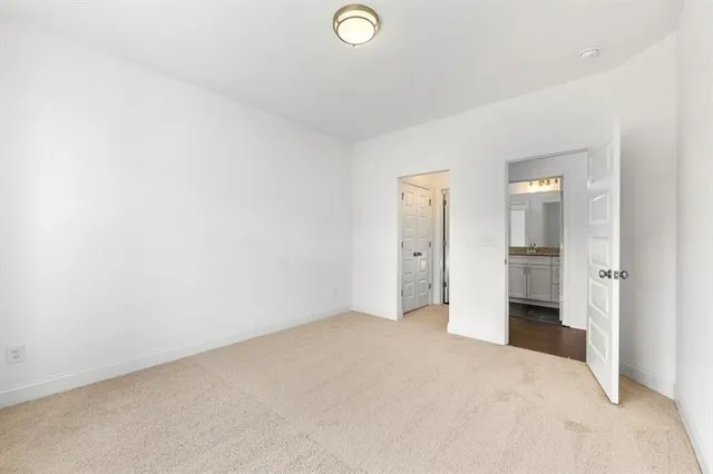 an empty room with closet and windows