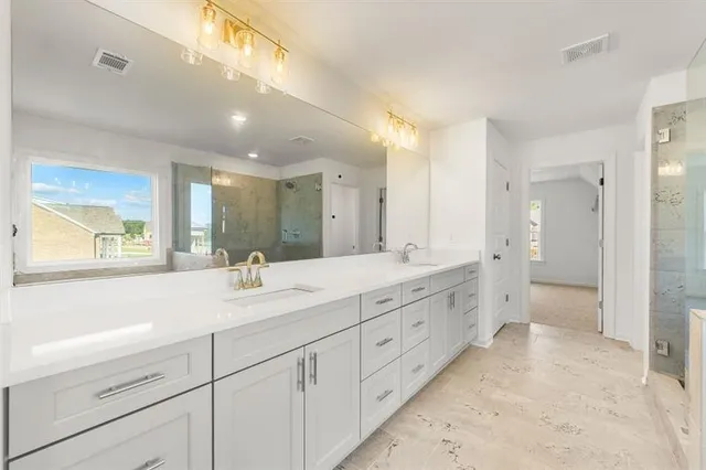 a spacious bathroom with a double vanity sink mirror and next to a window