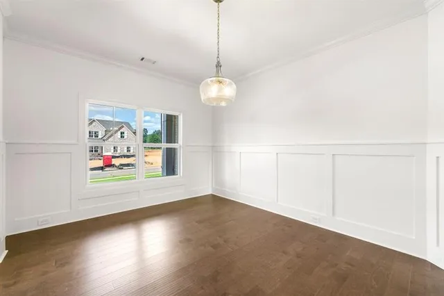 a view of a room with wooden floor and white walls