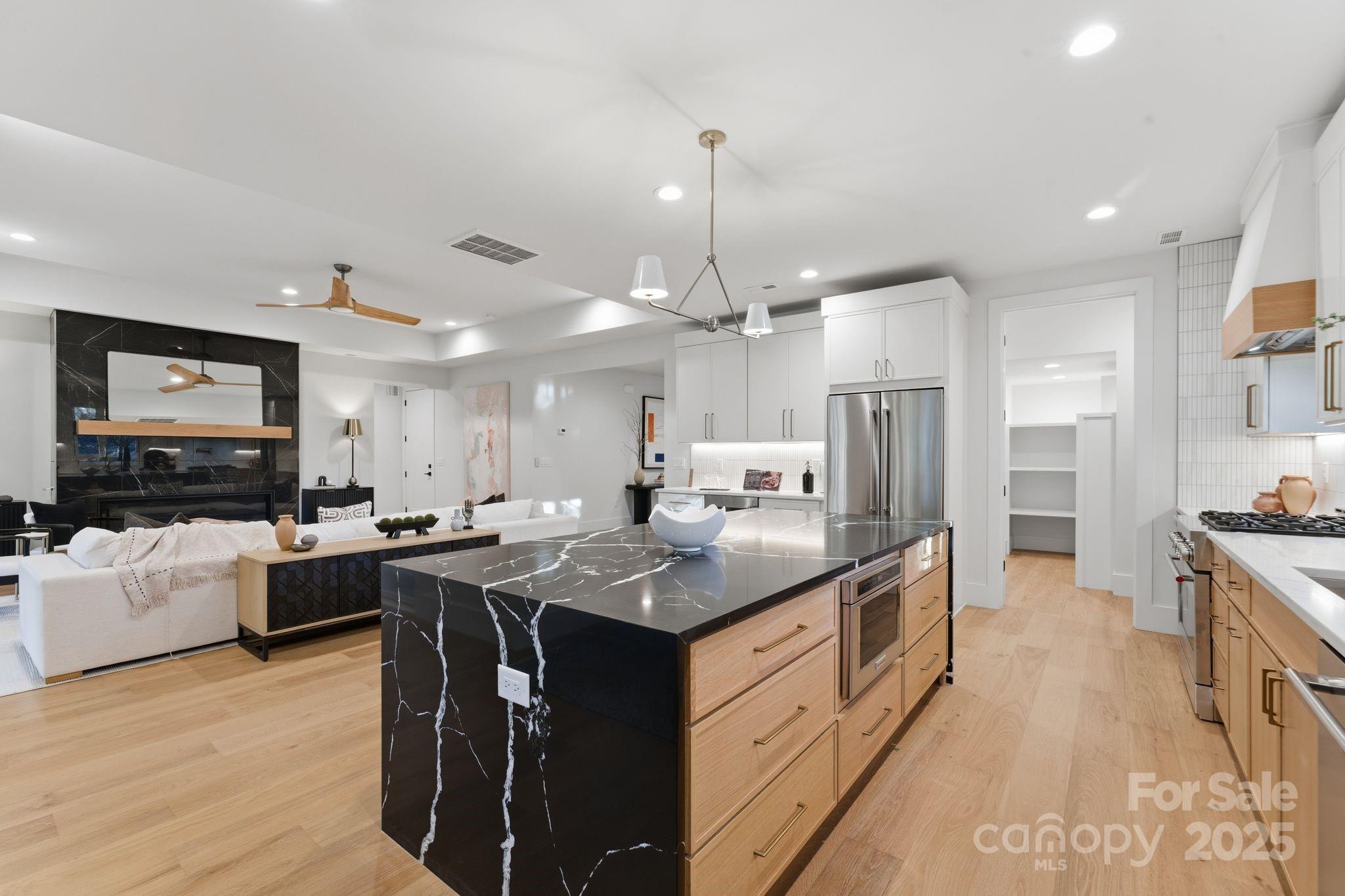 4658 Murrayhill Road Charlotte, NC 28209 - Photo 13 of 48 a kitchen with stainless steel appliances granite countertop a sink dishwasher a refrigerator and a dining table with wooden floor