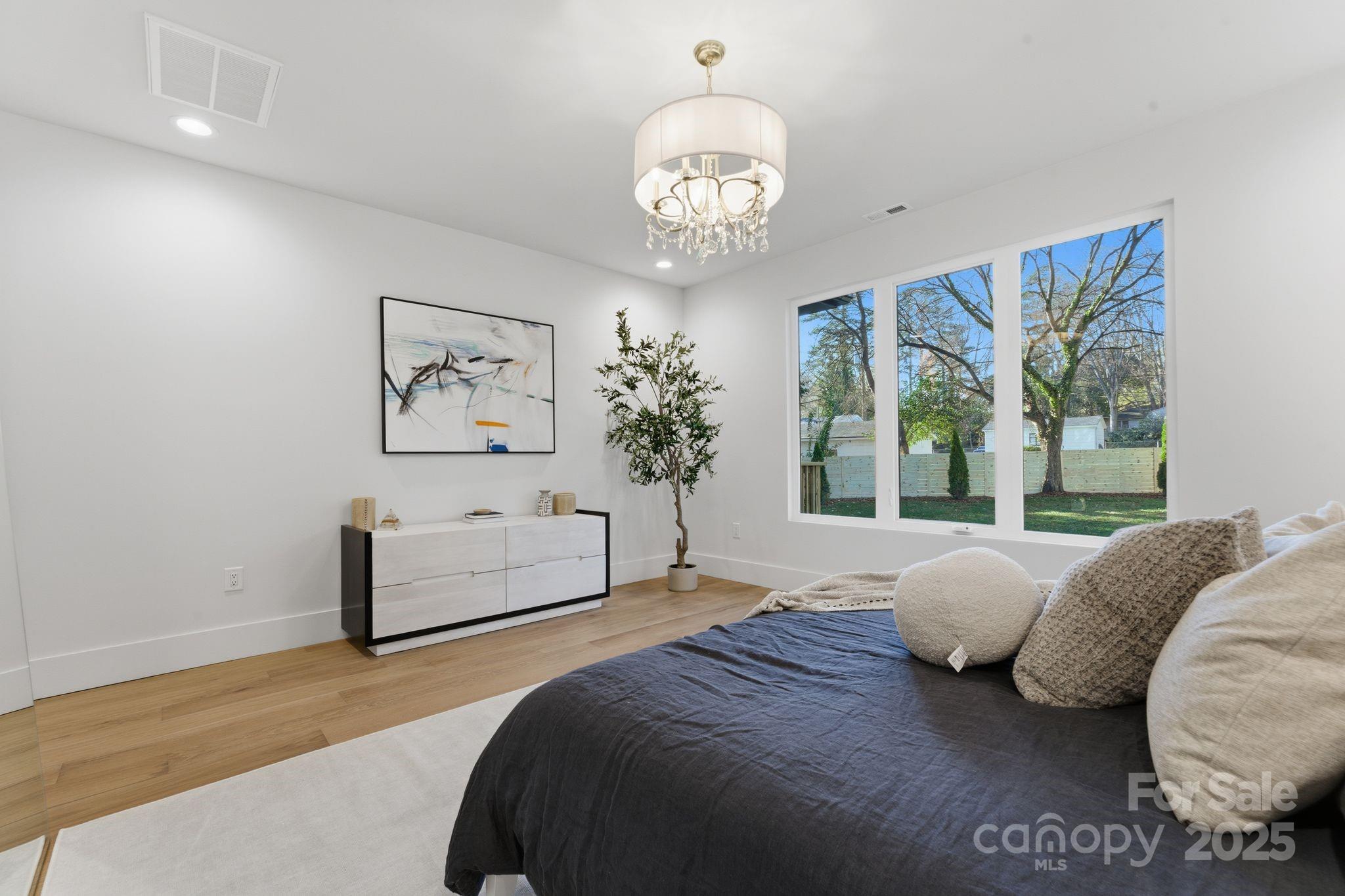 4658 Murrayhill Road Charlotte, NC 28209 - Photo 21 of 48 a spacious bedroom with a bed and a chandelier