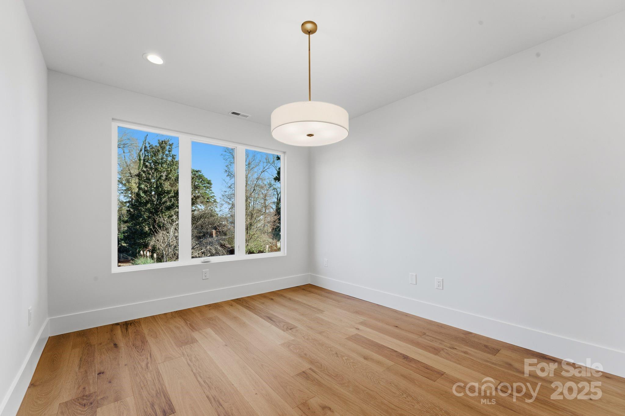 4658 Murrayhill Road Charlotte, NC 28209 - Photo 36 of 48 an empty room with wooden floor and windows