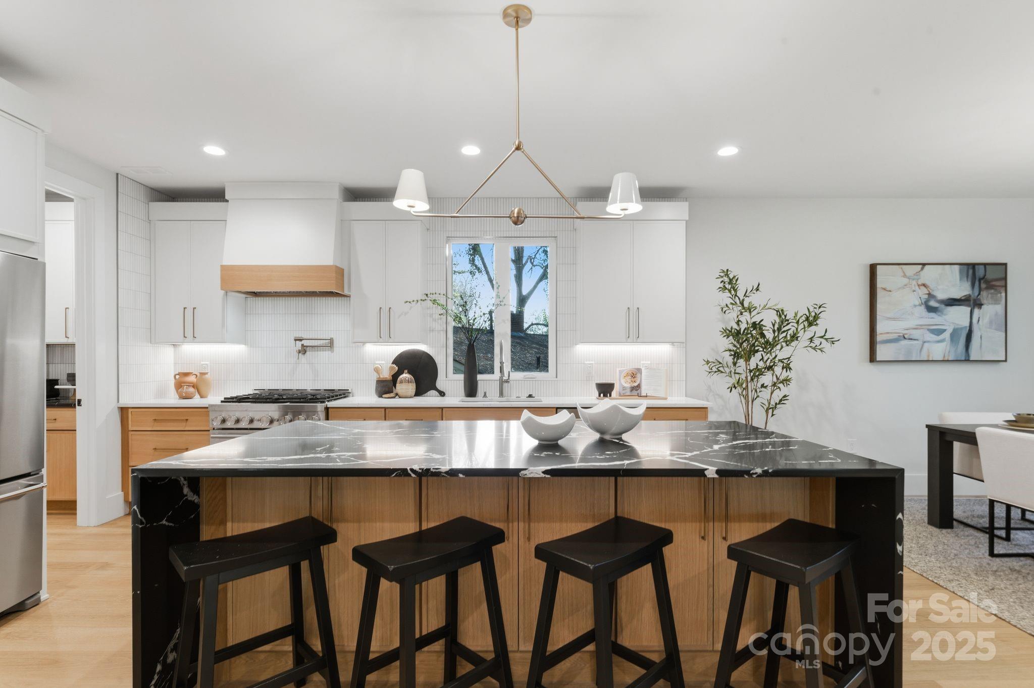 4658 Murrayhill Road Charlotte, NC 28209 - Photo 10 of 48 a kitchen with granite countertop a table chairs stove and cabinets
