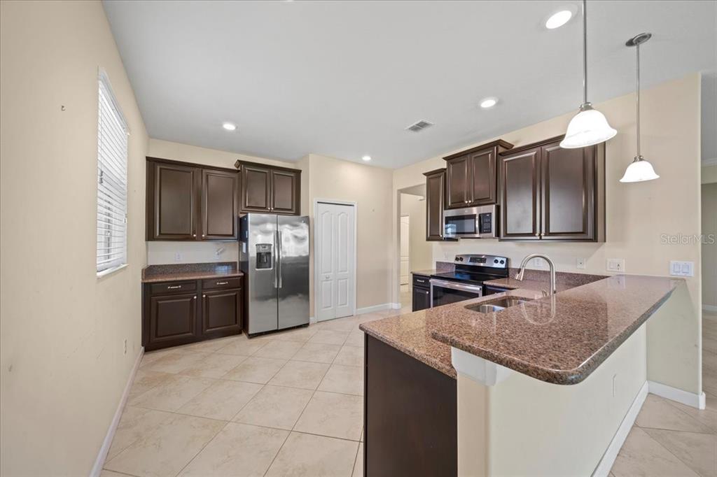 3565 Raleigh Drive Winter Haven, FL 33884 - Photo 13 of 73 a kitchen with stainless steel appliances granite countertop a sink refrigerator and microwave
