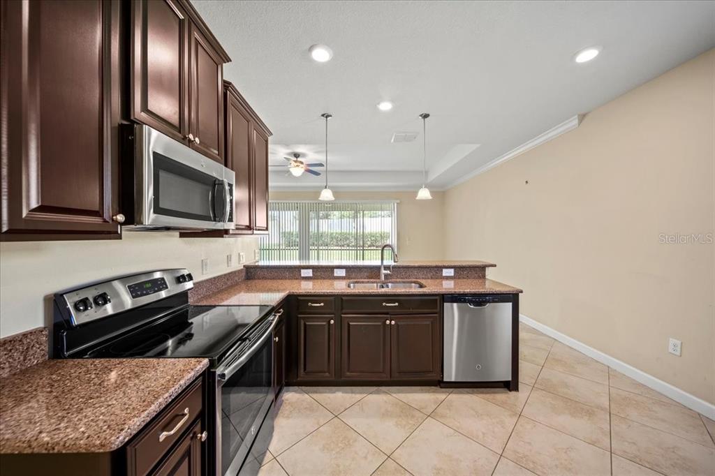 3565 Raleigh Drive Winter Haven, FL 33884 - Photo 16 of 73 a kitchen with stainless steel appliances granite countertop a stove a sink and a microwave
