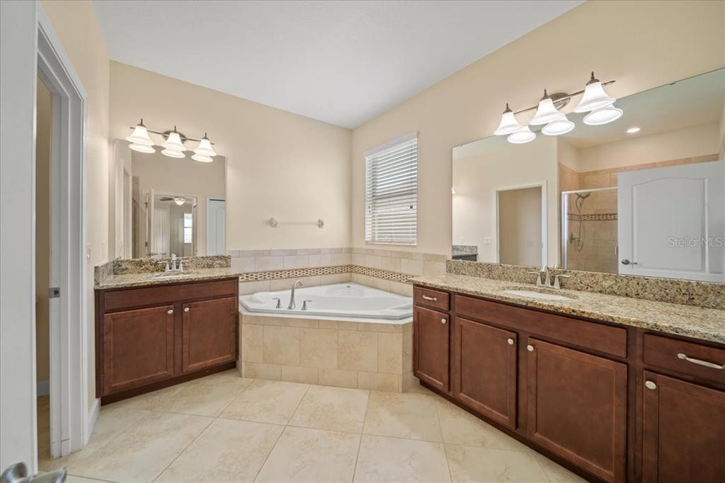 3565 Raleigh Drive Winter Haven, FL 33884 - Photo 24 of 73 a spacious bathroom with a granite countertop sink a large mirror and a bathtub