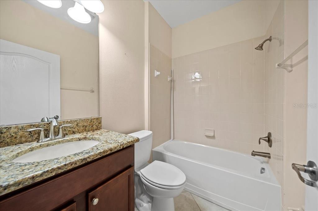 3565 Raleigh Drive Winter Haven, FL 33884 - Photo 33 of 73 a bathroom with a granite countertop sink a toilet and bathtub