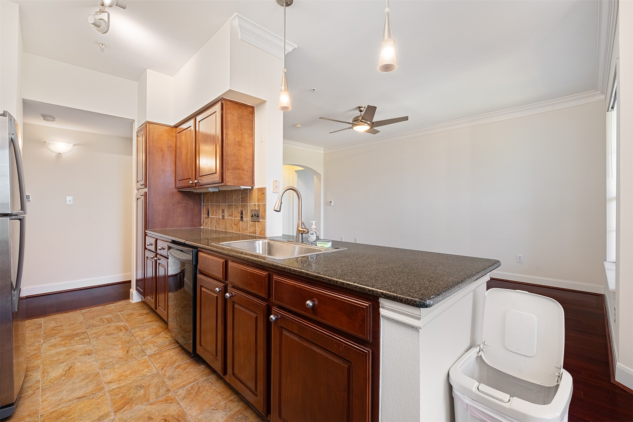 7701 Rialto Boulevard, Unit 637 Austin, TX 78735 - Photo 13 of 25 A well-appointed kitchen showcases rich cabinetry and a functional island, flowing into a bright living space.
