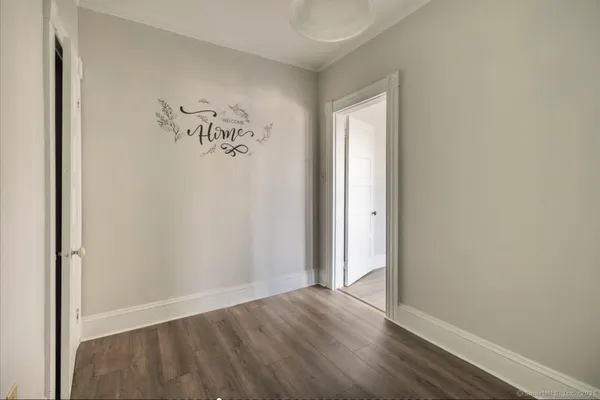an empty room with wooden floor and a window