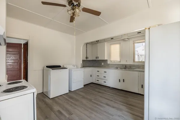 a kitchen with granite countertop white cabinets and white appliances