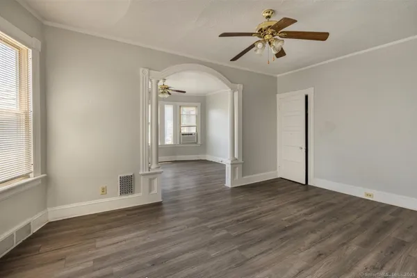a view of an empty room with window and wooden floor