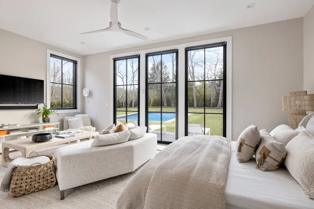 a bedroom with furniture and large windows