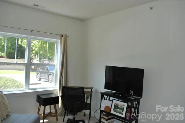 a view of a workspace with furniture and a window