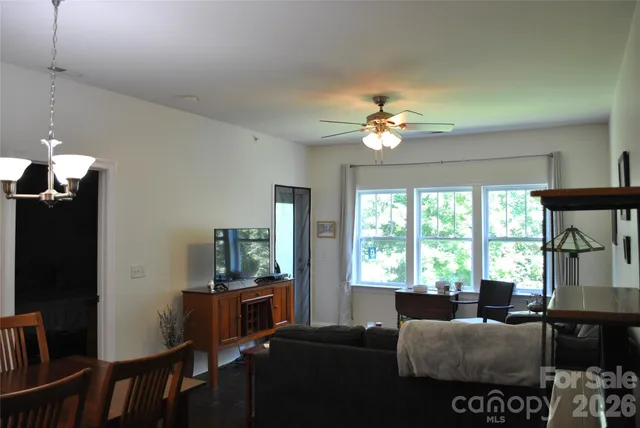 a living room with furniture a flat screen tv and a large window