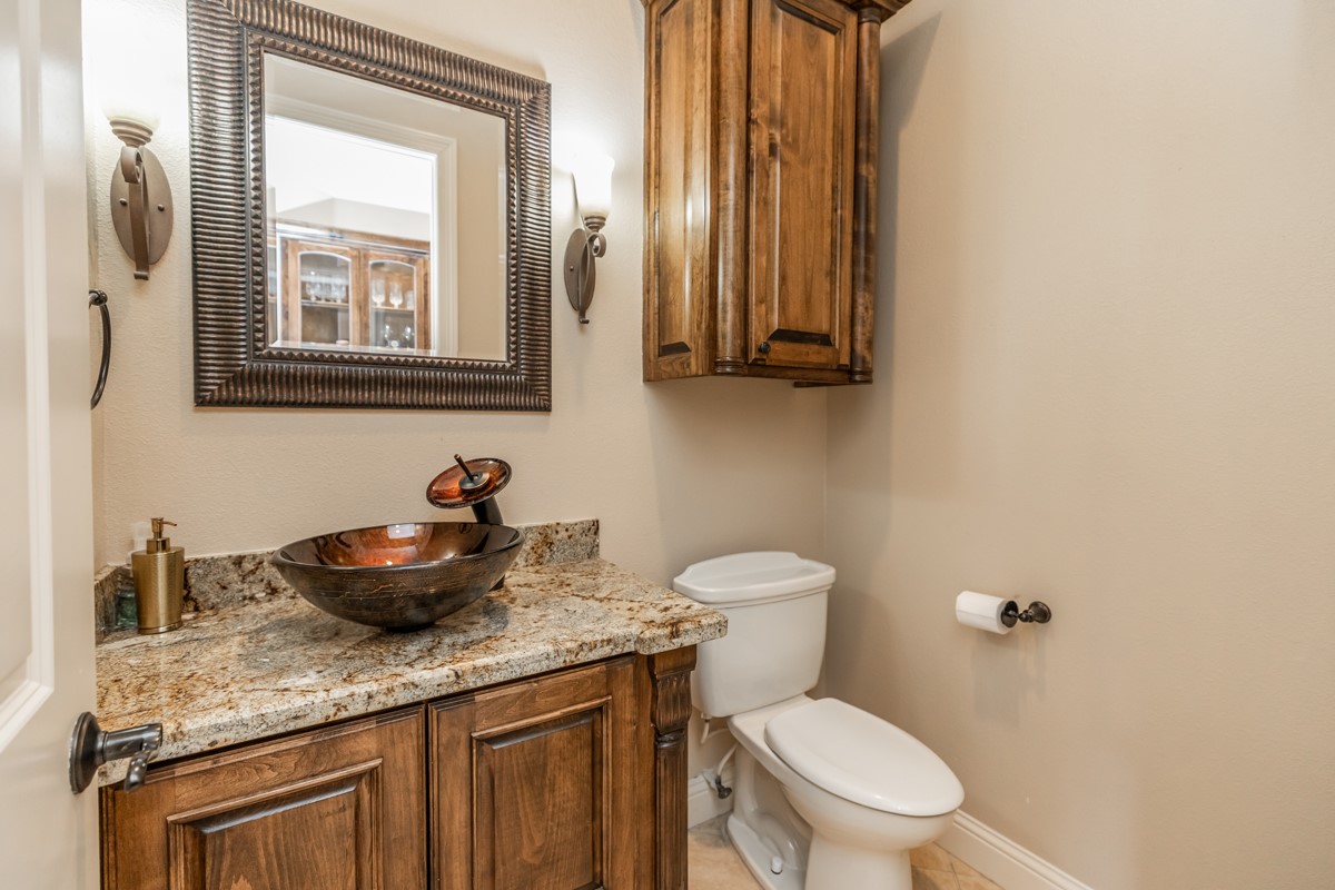 10940 Sheila Lane Beaumont, TX 77705 - Photo 12 of 50 a bathroom with a granite countertop toilet sink and mirror