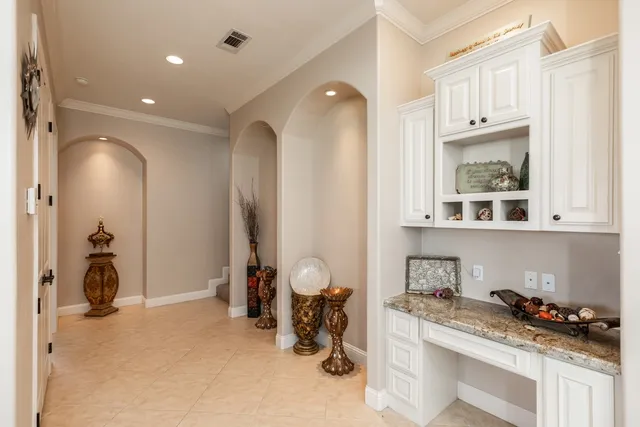 a bathroom with a granite countertop sink and white cabinets