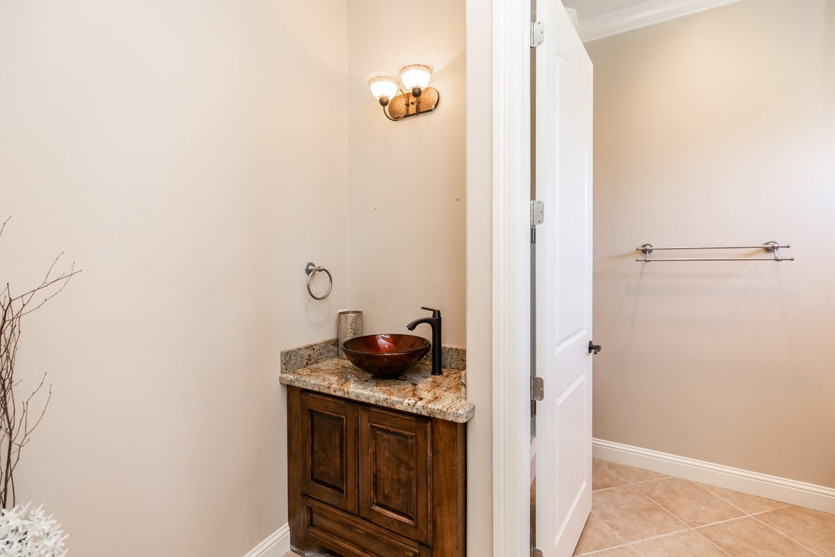 10940 Sheila Lane Beaumont, TX 77705 - Photo 34 of 50 a bathroom with a granite countertop sink and white cabinets