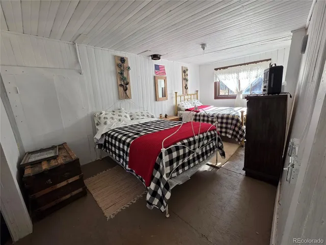 a bedroom with a bed painting on wall and a window