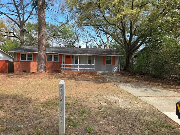 a front view of house with yard and trees around