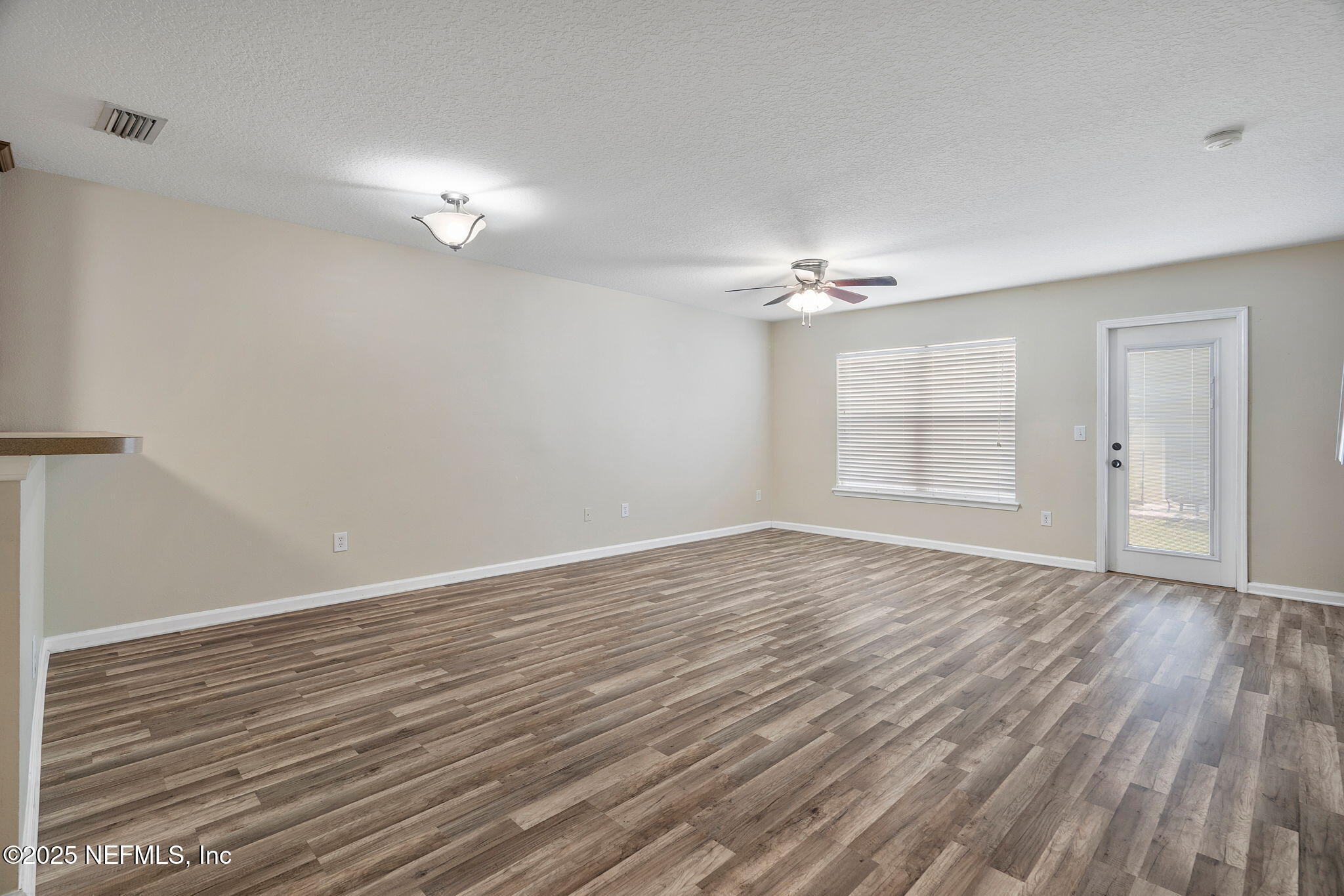 6700 Bowden Road, Unit 403 Jacksonville, FL 32216 - Photo 3 of 28 a view of an empty room with wooden floor and a window