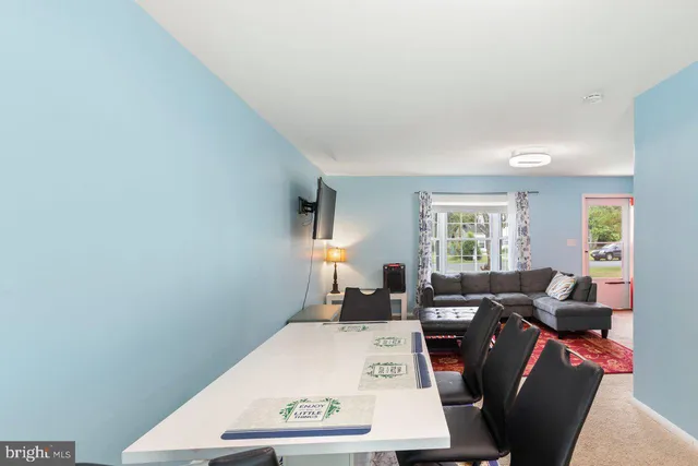 a view of a dining room with furniture a potted plant and wooden floor