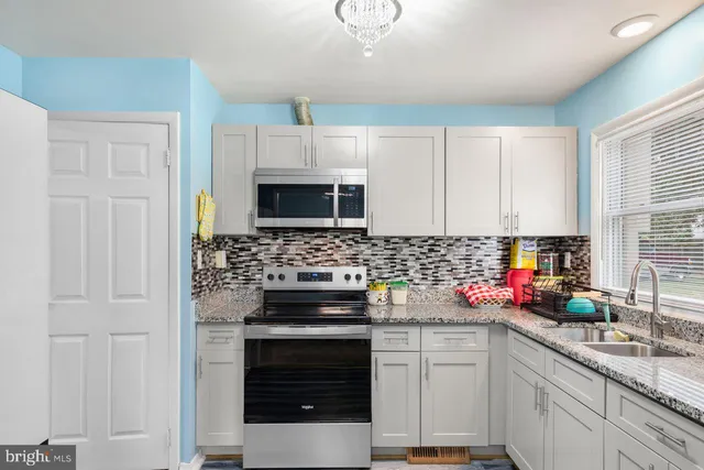 a kitchen with cabinets stainless steel appliances a sink and a window