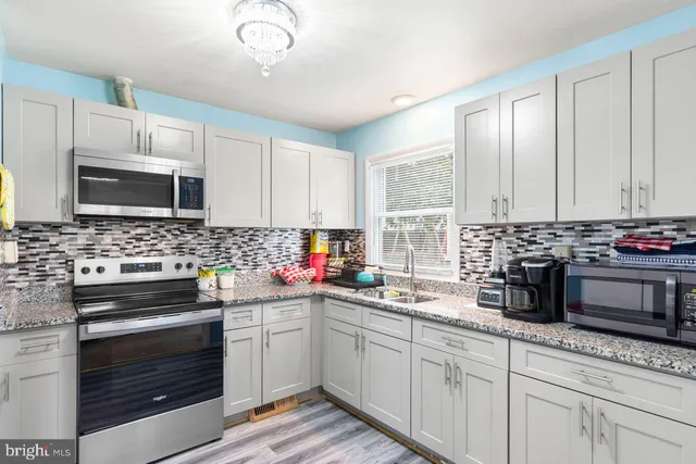 a kitchen with granite countertop a sink and a stove