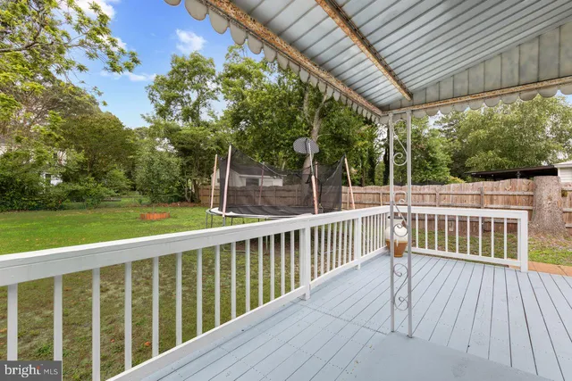 a view of a house with a yard deck and a chair